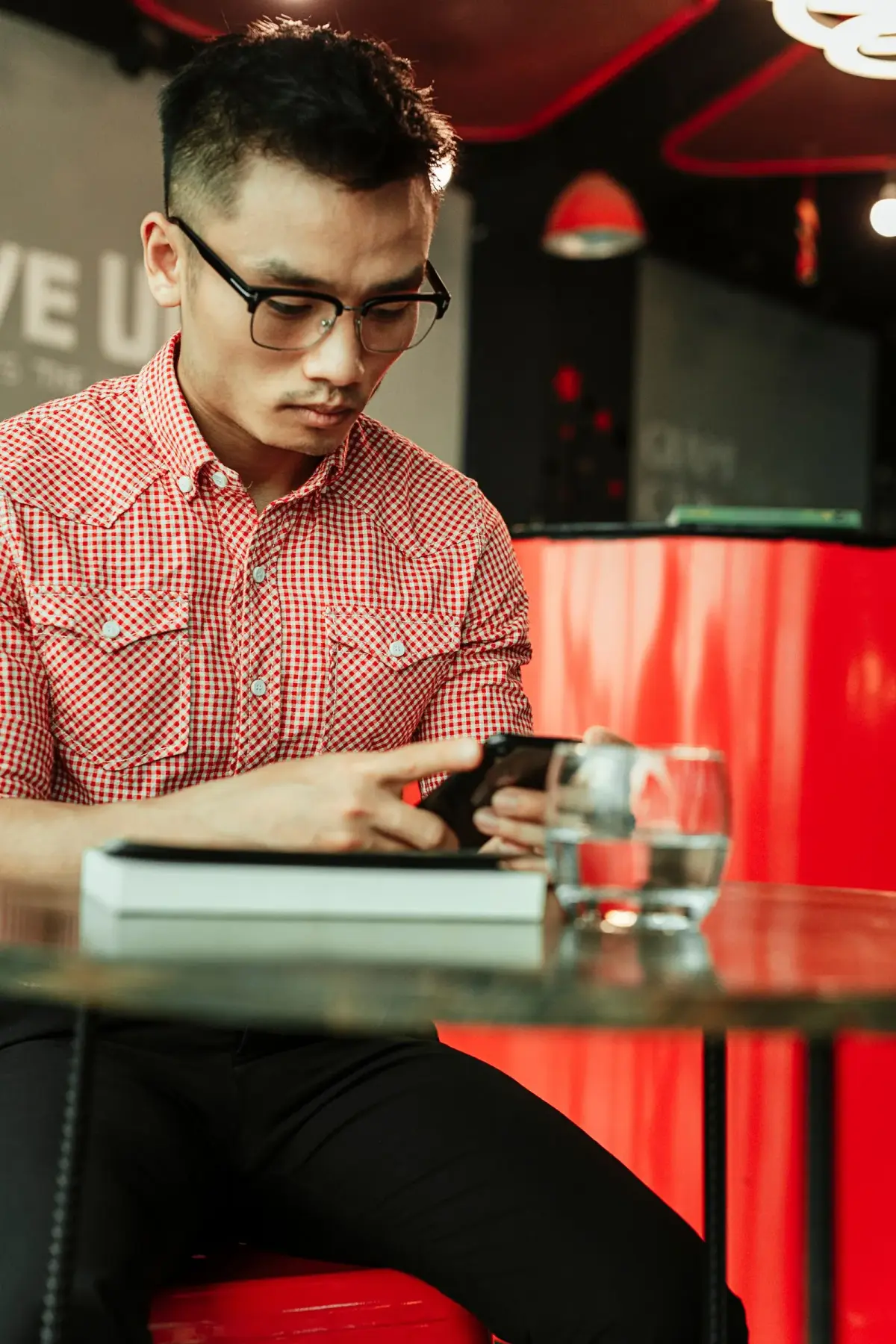 A man reading his phone in a café